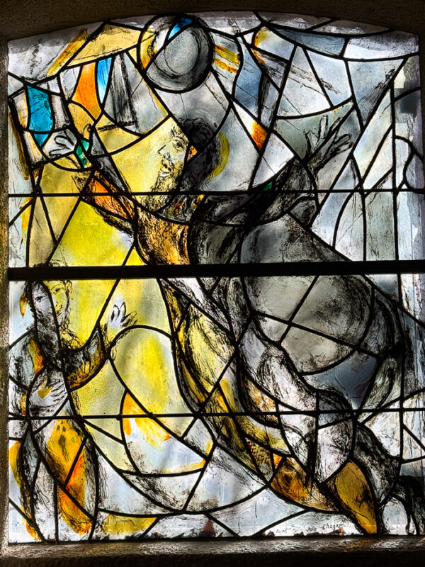 The Prophet Daniel window at Union Church, designed by Marc Chagall, with muted tones and imagery of Daniel’s ascension guided by angels.